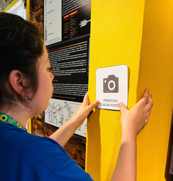 Niña colocando un pictograma en el museo