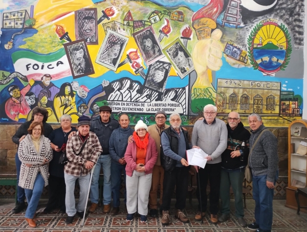 Integrantes de AJUPEN FOICA con el convenio firmado en mano